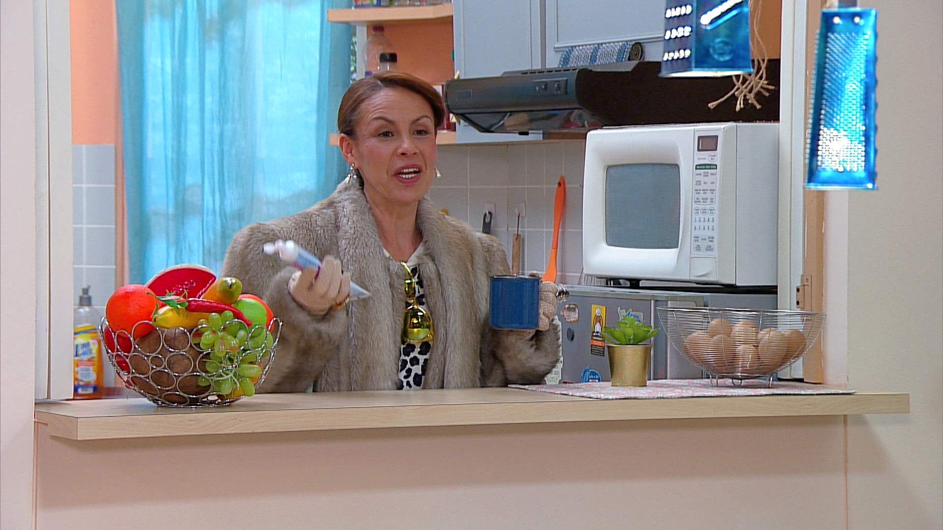 mujer en la cocina con una taza 