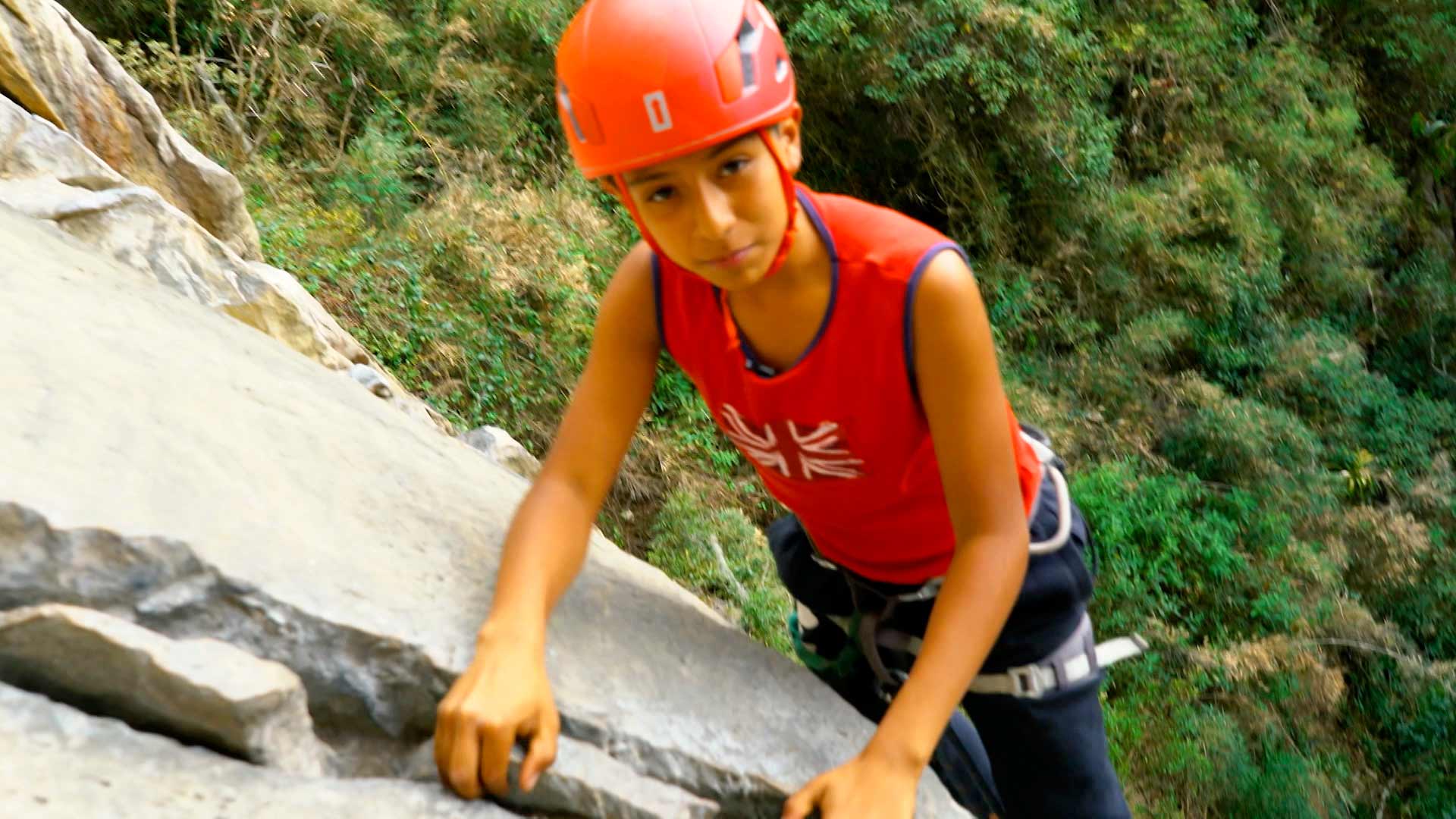 niño escalando roca