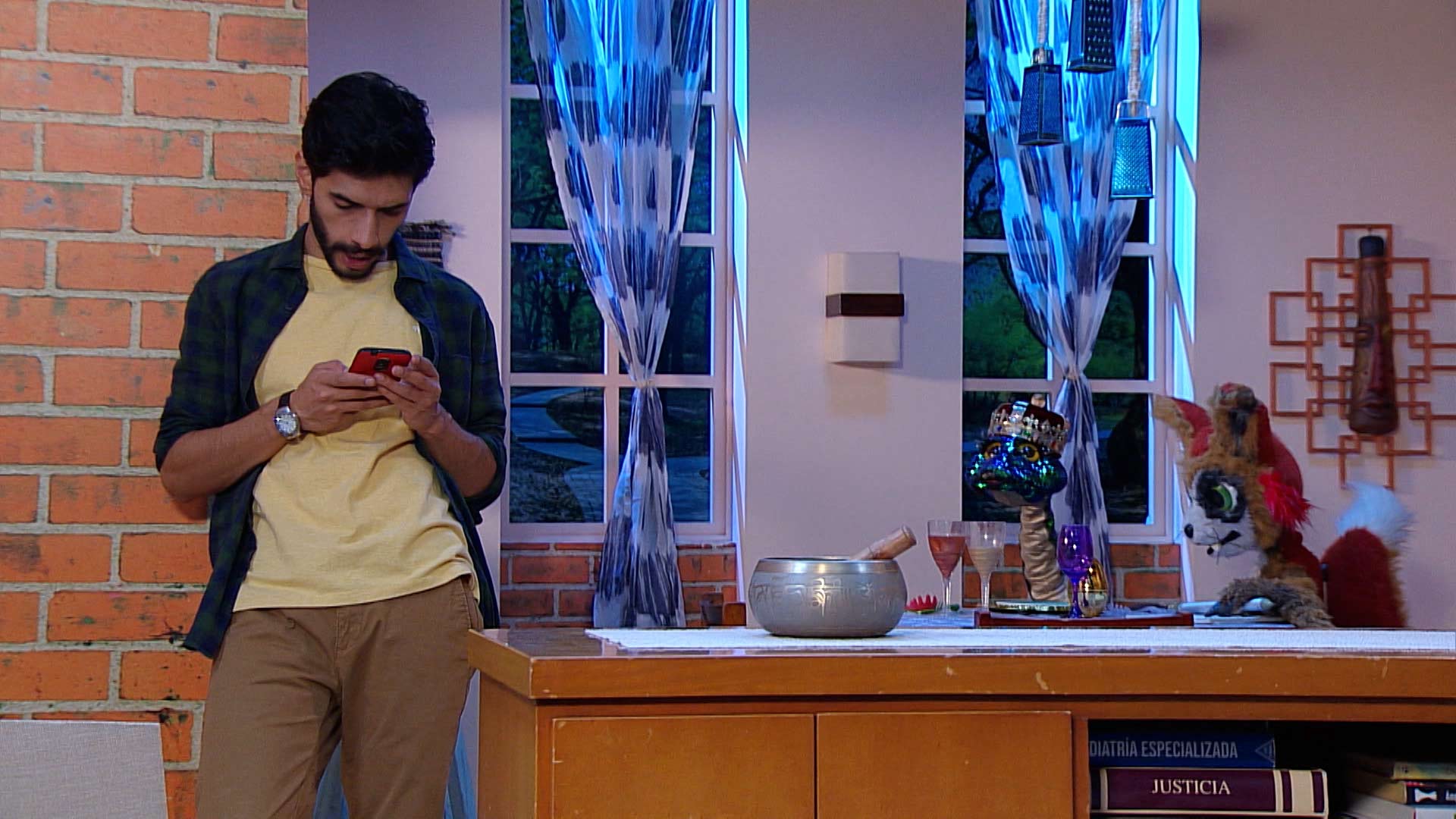 hombre mirando su celular con sus peluches 