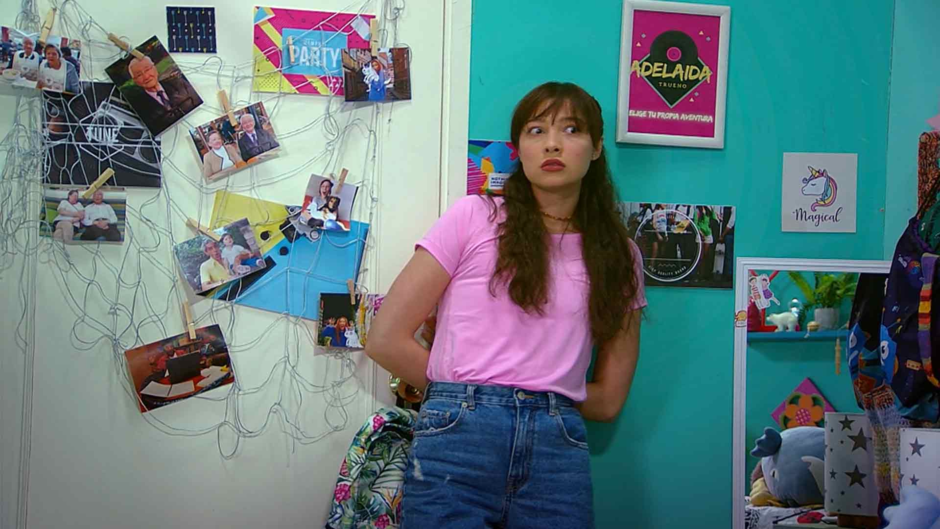 mujer rodeada de fotografías en su habitación