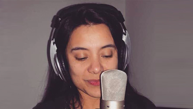 Mujer cantante frente al micrófono