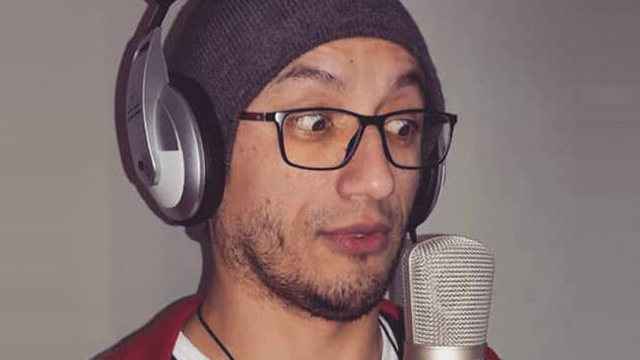 locutor con lentes, audífonos y micrófono