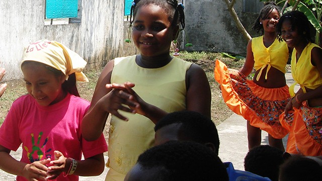grupo de niñas sonriendo y bailando con trajes típicos