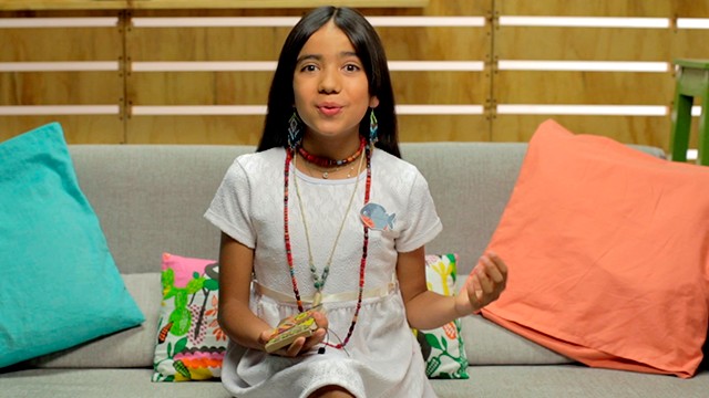 niña hablando en el sofá de su casa