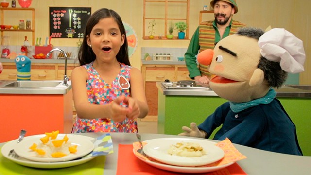 niña sorprendida hablando con un títere