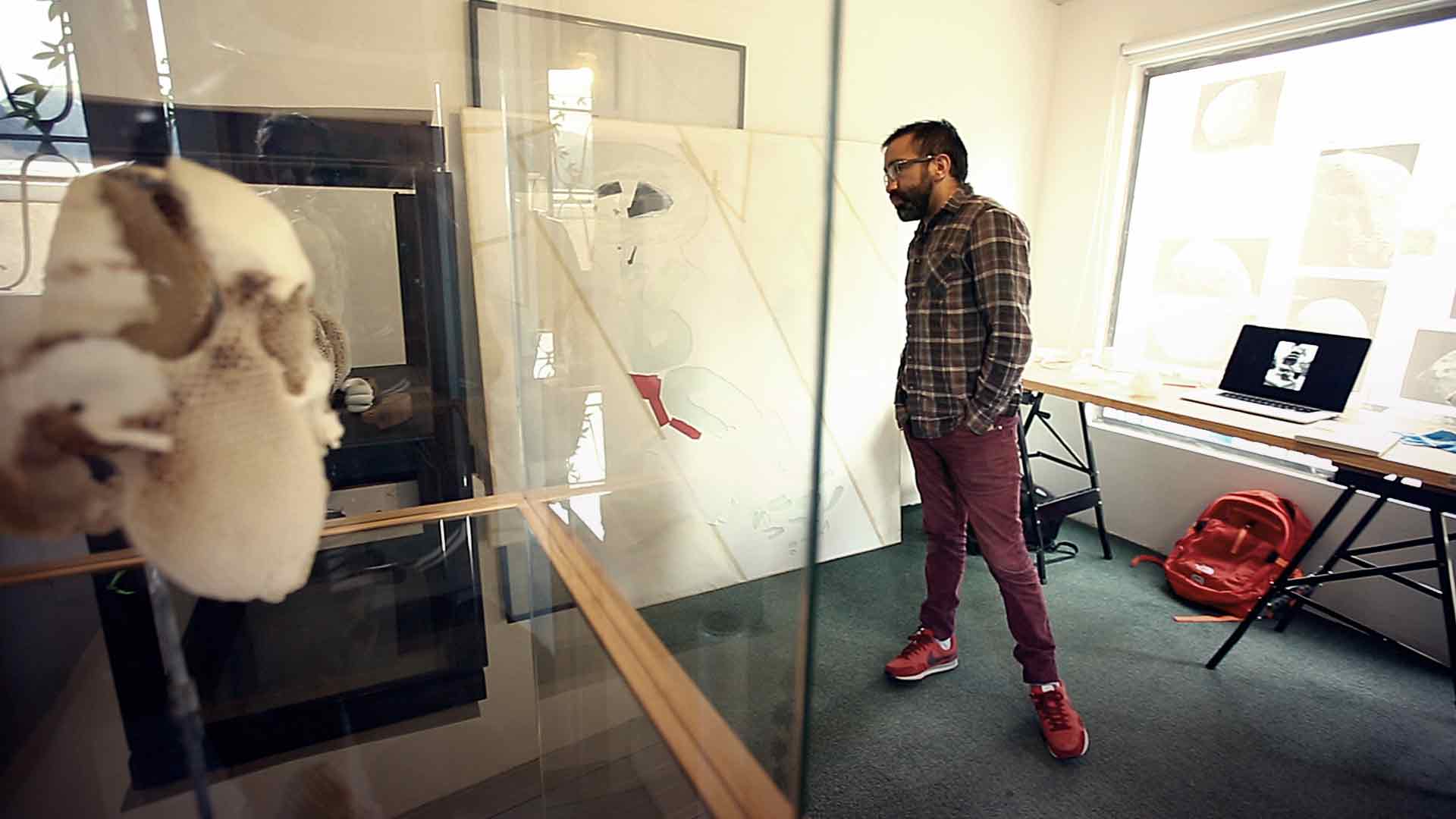Leonardo Ramos artista colombiano en su taller observando su obra Artecámara presenta