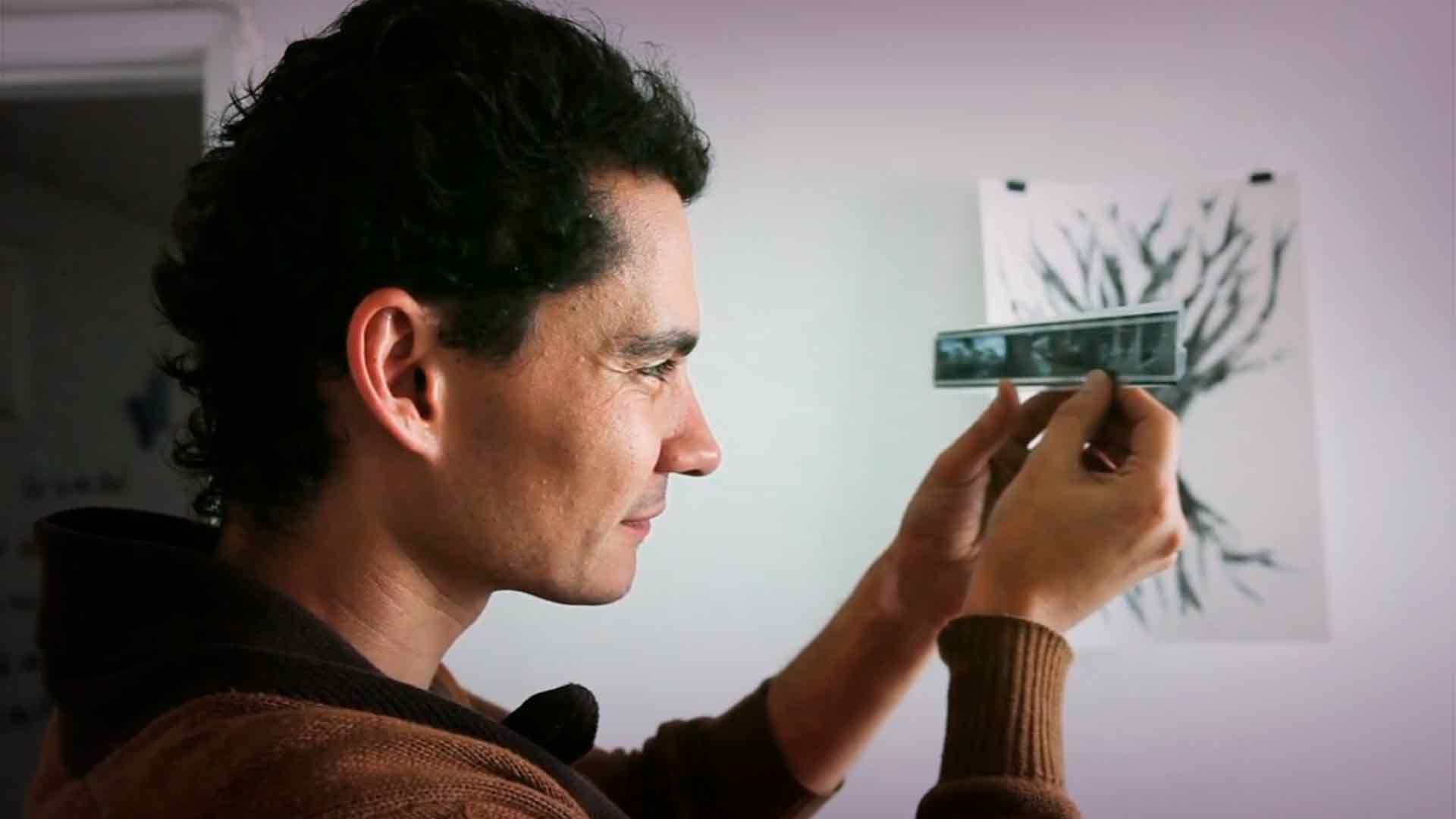 Alejandro Arango fotógrafo colombiano mira negativos con la luz del día Artecámara presenta