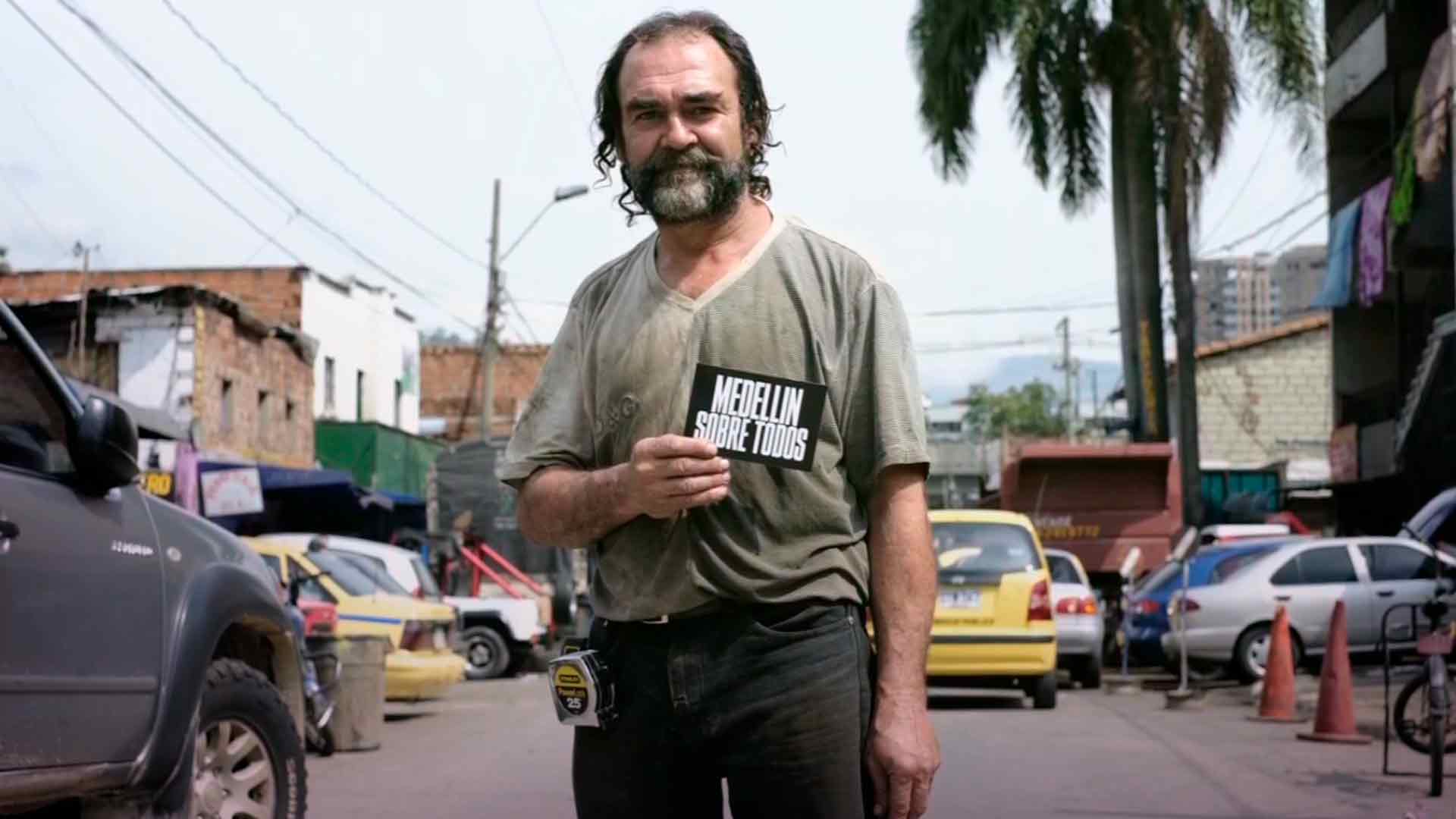 Hombre mayor desaliñado sostiene un letrero que dice: "Medellín sobre todos" serie documental Artecámara presenta