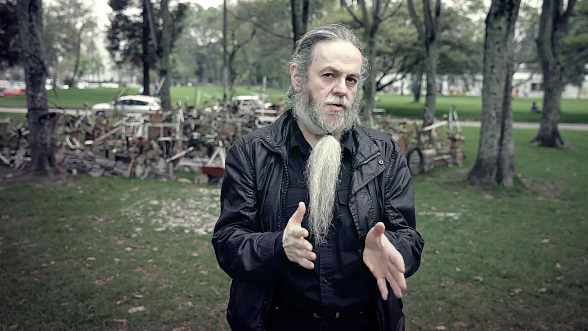 El artista Mauricio Bejarano con sus manos hacia al frente en un parque de la ciudad Artecámara presenta serie documental