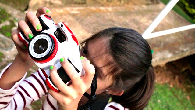 niña tomando fotos con cámara.
