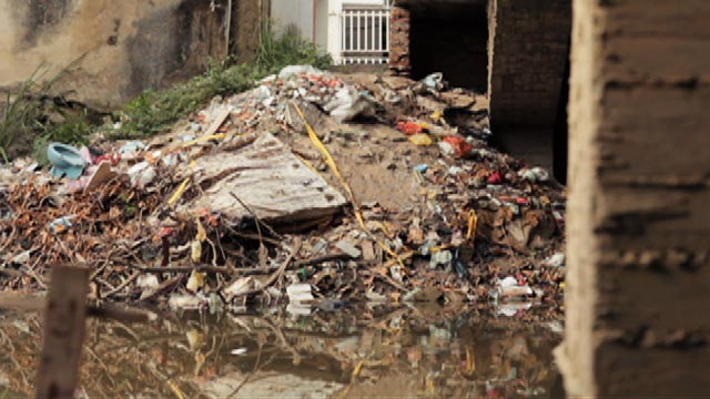 Montaña de basura y desechos al lado de una fuente hídrica 