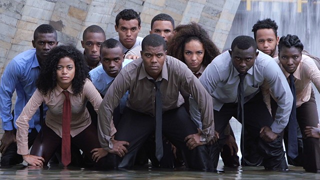 Grupo de jóvenes afrocolombianos de rodillas con expresión seria