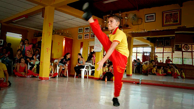 Niño abriéndose de piernas de pie