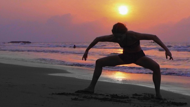 mujer bailando sobre la playa al atardecer