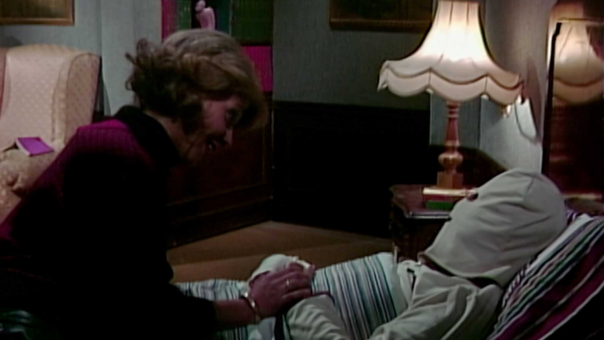 persona en cama con cabeza tapada mientras alguien la cuida