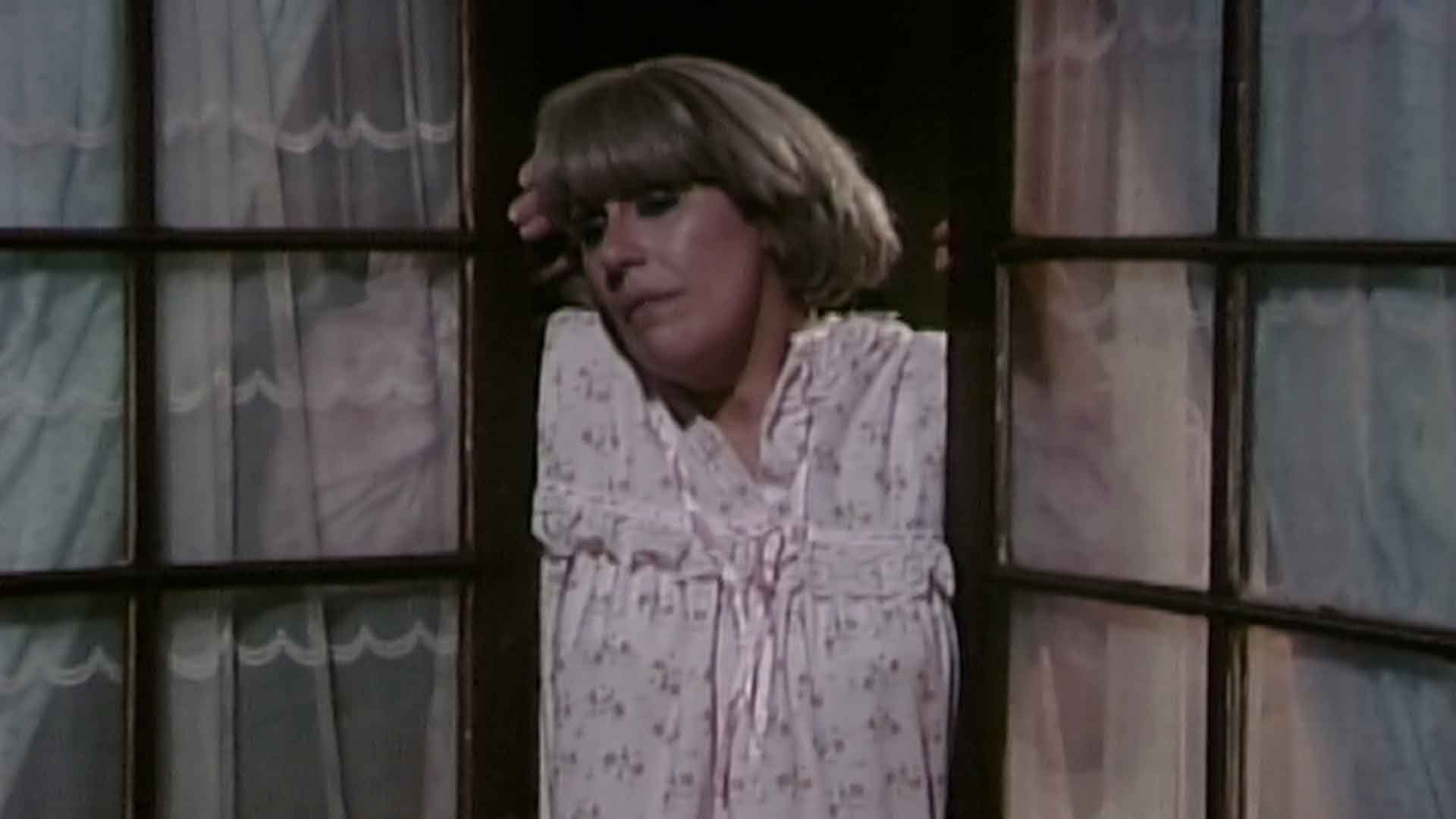 Narcisa Olmedo, protagonista de la serie de misterio colombiana Los Cuervos, mirando por la ventana con mucha tristeza