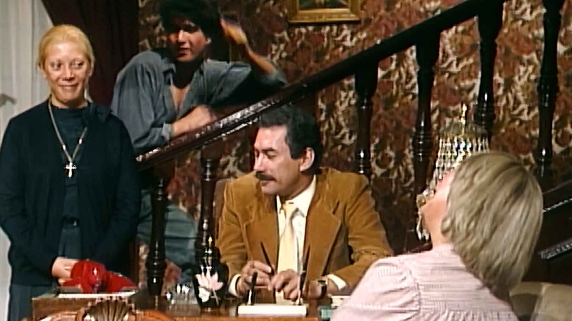 Santiago, Narcisa y otros miembros de la familia Olmedo reunidos en el comedor de la mansión donde fue grabada la popular serie de misterio colombiana