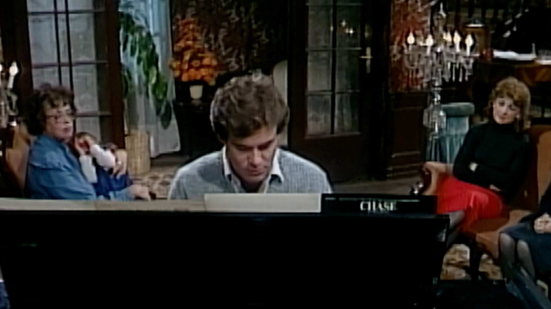 Miembros de la familia Olmedo se reúnen alrededor del piano dispuesto en la sala