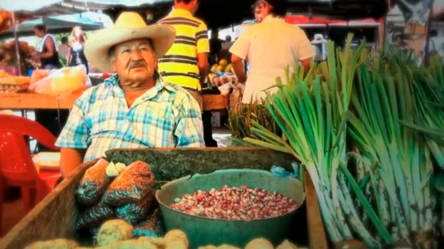 Campesino sentado en una plaza de mercado