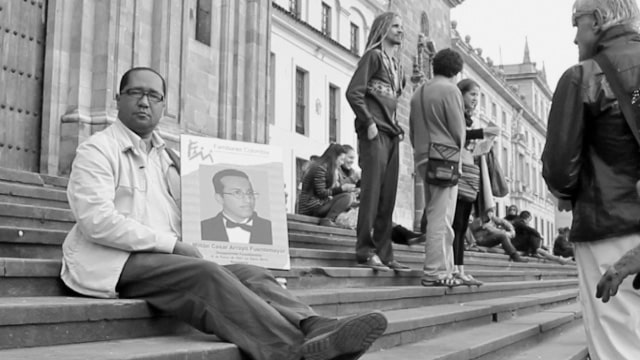 Hombre con un cartel de un desaparecido - Perfiles contra el olvido