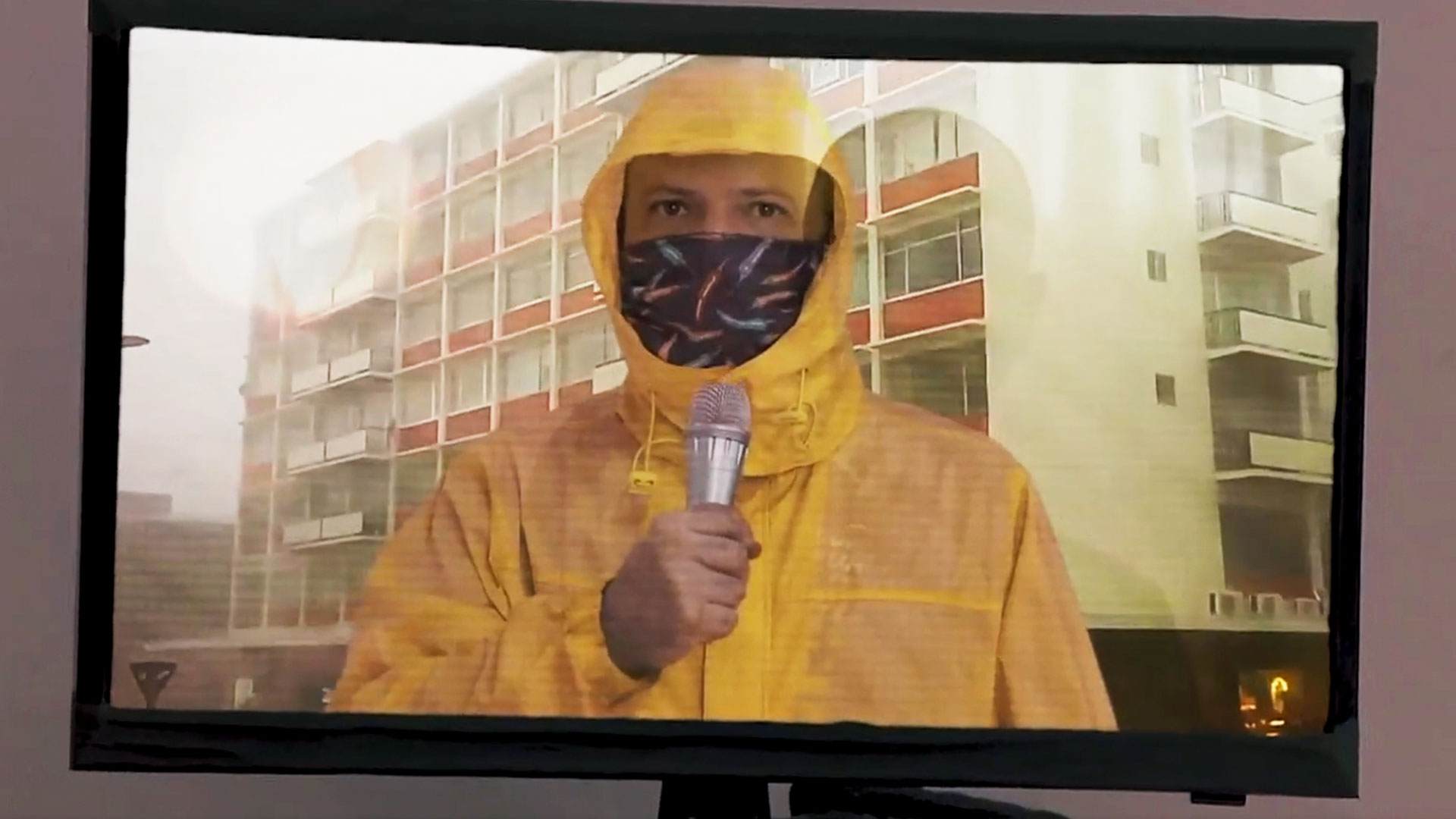 un reportero con impermeable y micrófono dando el reportaje