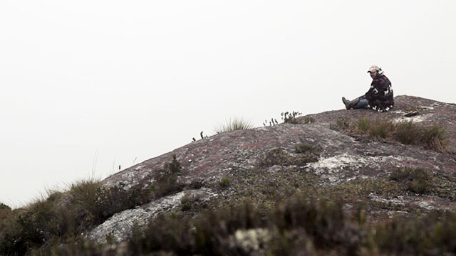 hombre sentado en una montaña