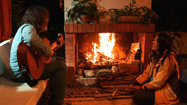 Jazmín Ramírez tocando guitarra junto a la chimenea anónimas extraordinarias